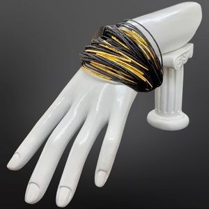 Corded bracelet interlaced with gold metal accents. Magnetic closure